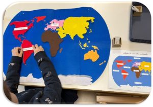 Bambino con carte geografiche Montessori - scuola primaria Montessori